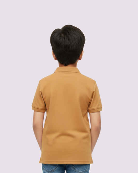 Stylish boys mustard polo shirt paired with blue jeans studio portrait.