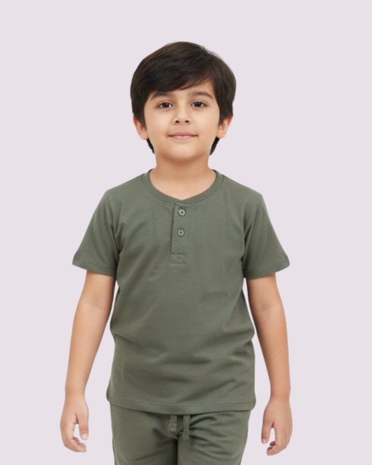 Child wearing a green shirt and pants on a light gray background